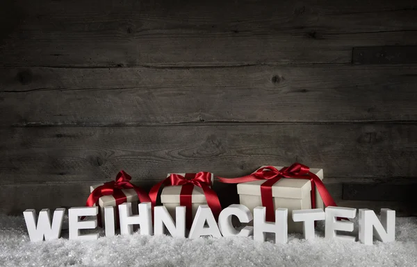 Wooden background with presents and the text christmas in german — Stock Photo, Image