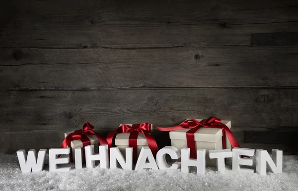 Dřevěné pozadí s dárky a text Vánoce v němčině Royalty Free Stock Fotografie
