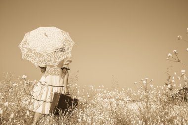 Nostalgic old photo in sepia color. Girl with her umbrella walki