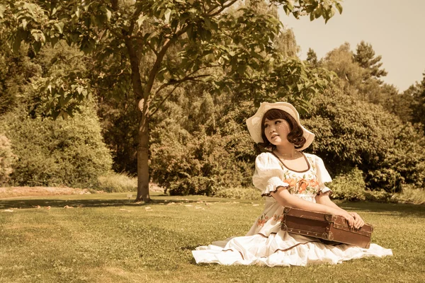 Waiting girl with her luggage wearing a beautiful country style Royalty Free Stock Images