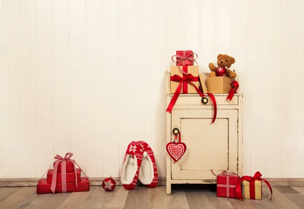 Christmas presents and gifts in red and white colors on old wood — Zdjęcie stockowe