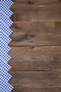 Old wooden background with blue and white checked border for bav