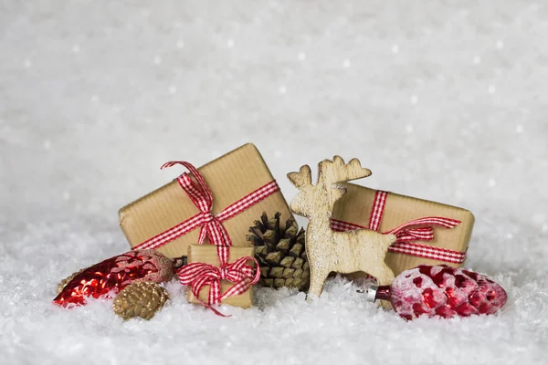 Scatole regalo bianche rosse selezionate su sfondo nevoso con rei in legno — Foto Stock