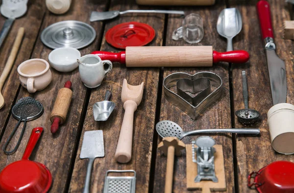 Old dishes and cutlery on a wooden background in red, silver and — Stock Photo, Image