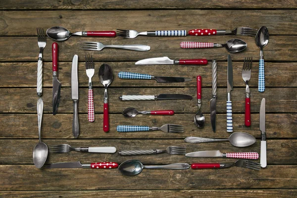 Çatal bıçak takımı ile oluşan bir koleksiyon ile eski ahşap arka plan — Stok fotoğraf