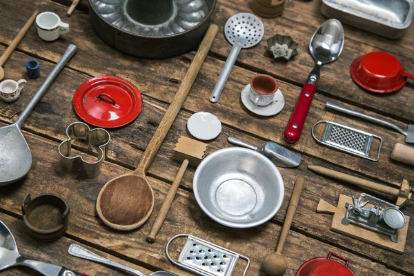 Old dishes and cutlery on a wooden background in red, silver and — Stock Photo, Image