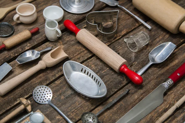 Old dishes and cutlery on a wooden background in red, silver and — Stock Photo, Image