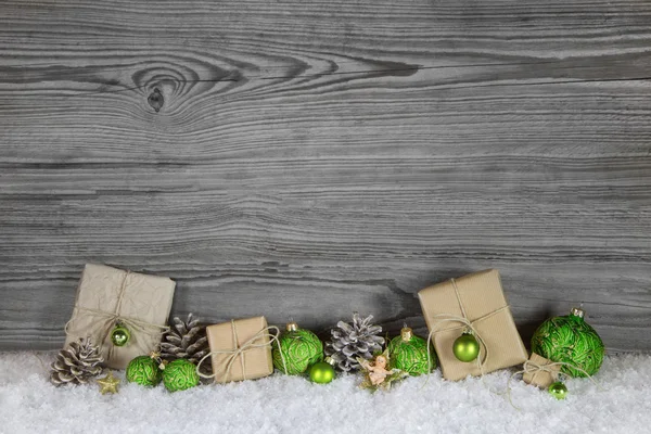 Green Christmas presents wrapped in natural paper on old wooden Royaltyfria Stockbilder