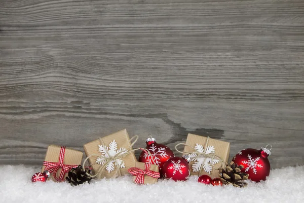 Presentes de Natal vermelhos embrulhados em papel natural em gr de madeira velha Imagem De Stock