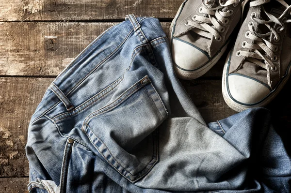 Dirty old jeans and sneakers — Stock Photo, Image