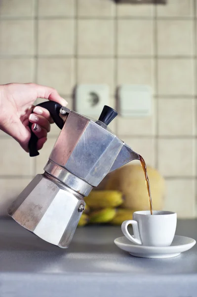 Mão perto derramando café expresso em uma xícara — Fotografia de Stock