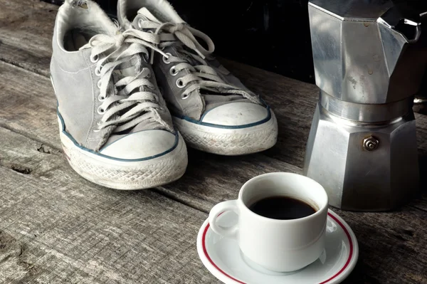 Кофе эспрессо, кофеварка и грязные кроссовки — стоковое фото