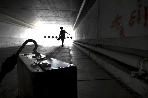 Suitcase and umbrella in an underpass — Stock Photo, Image