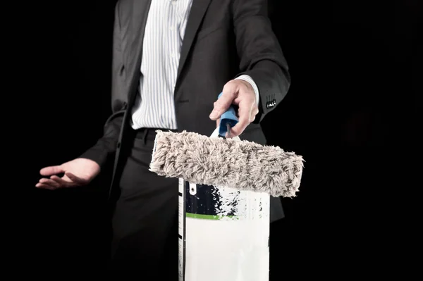 Βusinessman holding paint roller and a bucket of paint — Stock Photo, Image