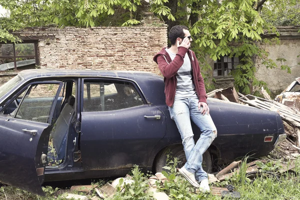 Young adult man leaning on a car — Stock Photo, Image