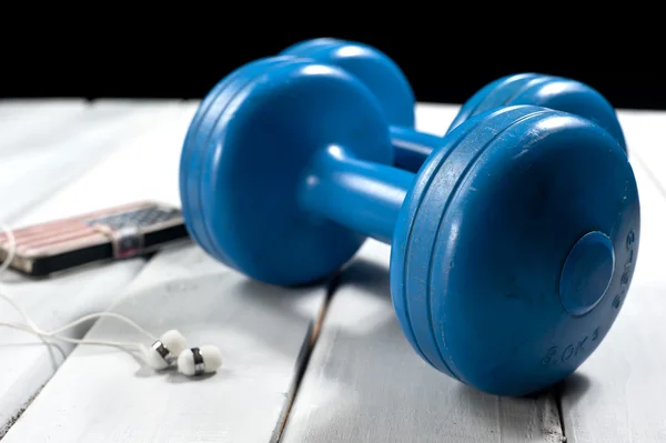 Dumbbells and smartphone on floor — Stock Photo, Image