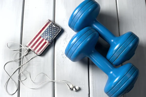 Dumbbells and smartphone on floor — Stock Photo, Image