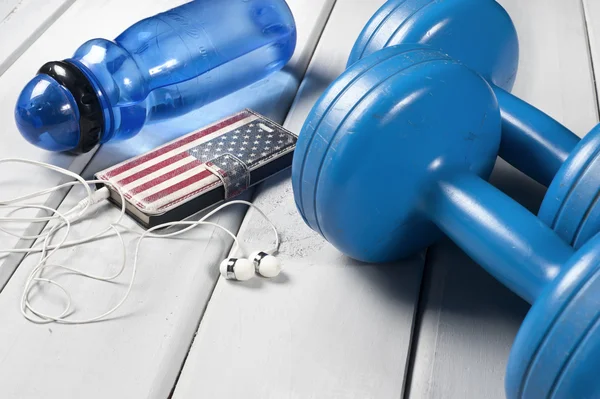 Dumbbells, plastic bottle of water and smartphone with headphones — Stock Photo, Image