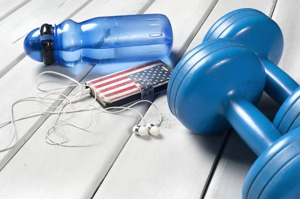 Dumbbells, plastic bottle of water and smartphone with headphones — Stock Photo, Image