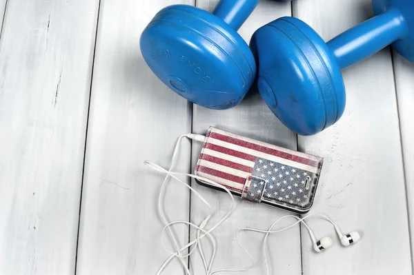 Dumbbells and smartphone on floor — Stock Photo, Image