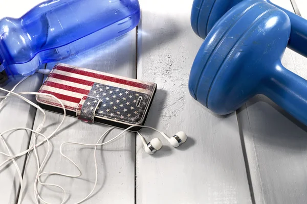 Dumbbells, plastic bottle of water and smartphone with headphones — Stock Photo, Image