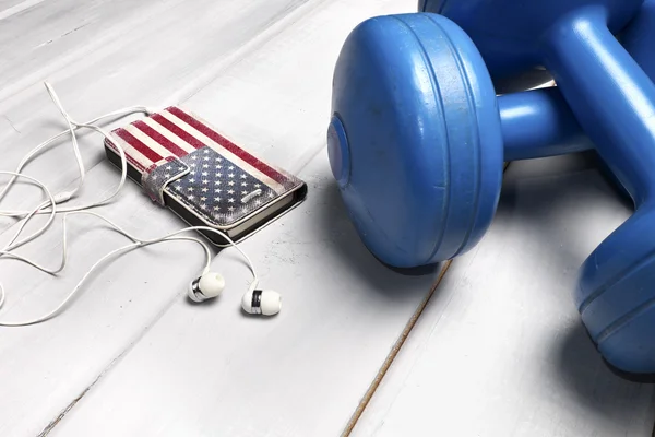 Dumbbells and smartphone on floor — Stock Photo, Image