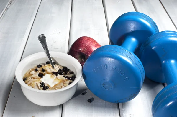 Hanteln und roter Apfel neben Schüssel mit Joghurt — Stockfoto