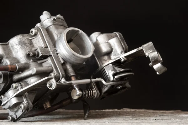 Carburetor on wooden surface ロイヤリティフリーのストック画像