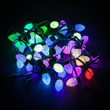 Siyah arkaplanda parıldayan LED yılbaşı ışıkları.