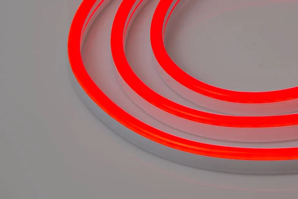Flexible red led neon decor light glowing on dark background.