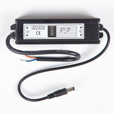 LED sürücü güç kaynağı ac adaptörü beyaz arka planda varil connetor ile siyah konutta.