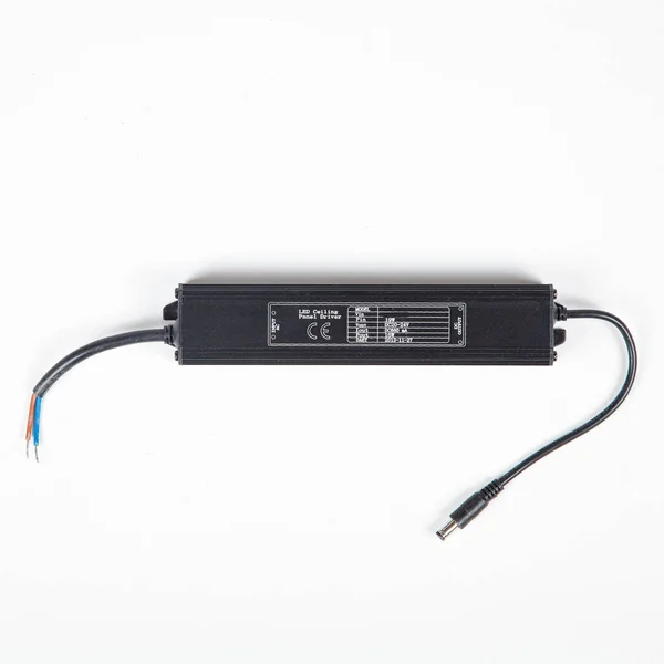 LED sürücü güç kaynağı ac adaptörü beyaz arka planda varil connetor ile siyah konutta.