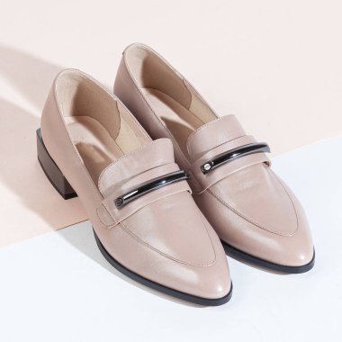 Beyaz arka planda uzun gölgeli kadın ayakkabıları.