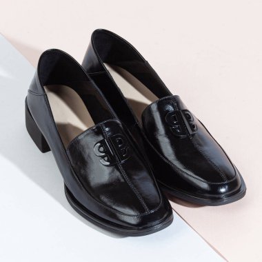 Beyaz arka planda uzun gölgeli kadın ayakkabıları.