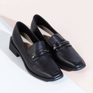 Beyaz arka planda uzun gölgeli kadın ayakkabıları.