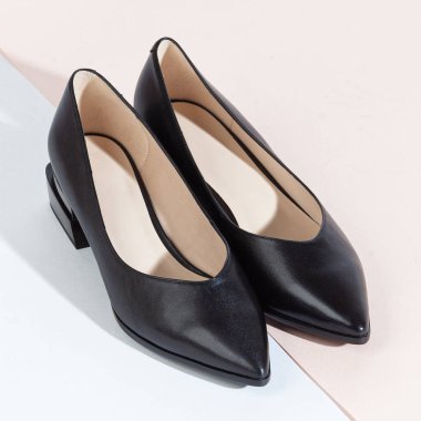 Beyaz arka planda uzun gölgeli kadın ayakkabıları.