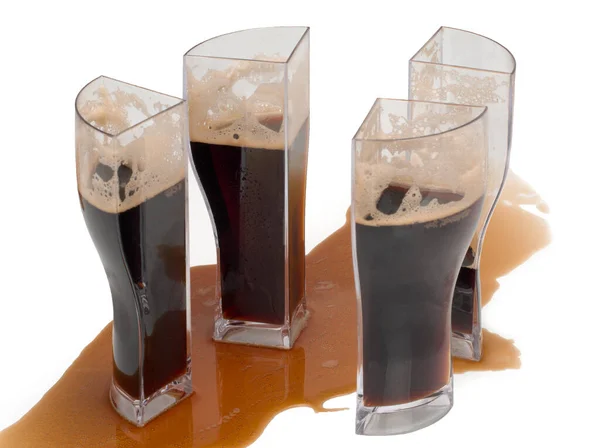 Mörkt öl i fyra glas som kan kombineras till ett glas. Glas, indelat i fyra delar — Stockfoto