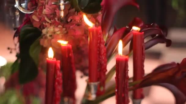 Candele rosse che bruciano sullo sfondo di un fiore — Video Stock