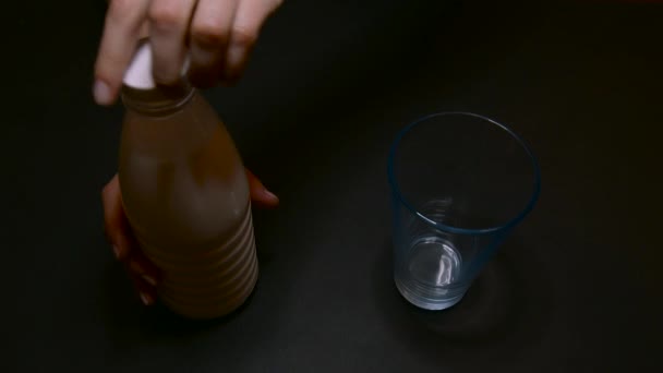 Наливание из бутылки в стакан молока — стоковое видео