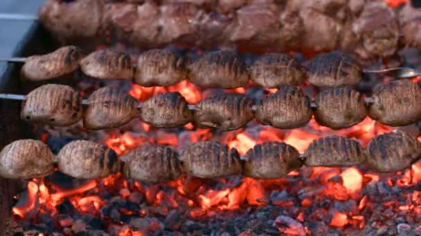 Aardappel plakjes gekookt op een spies boven houtskool — Stockvideo