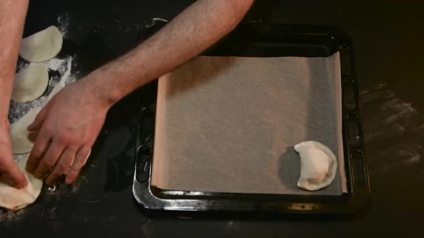 L'uomo mette le torte su un foglio di cottura per cuocere — Video Stock