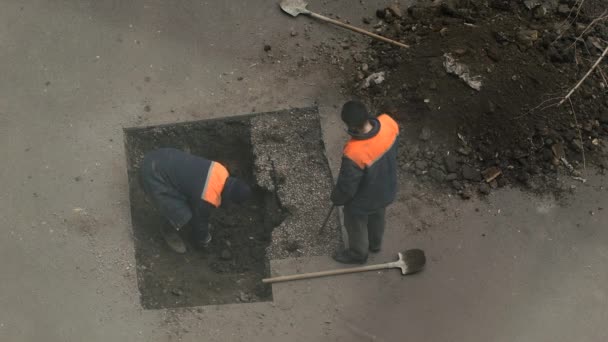 El trabajo rompe terreno bajo el asfalto en el pozo — Vídeos de Stock