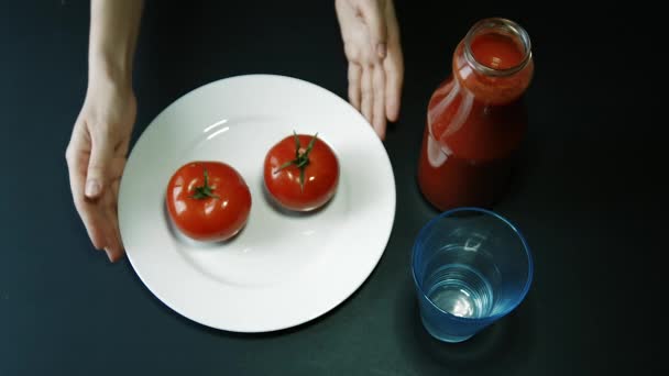 Piatto di giro della mano con due pomodori su un tavolo — Video Stock