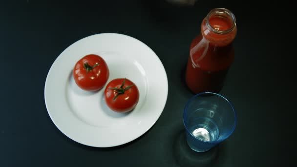 Hand gießt Tomatensaft aus einer Glasflasche — Stockvideo