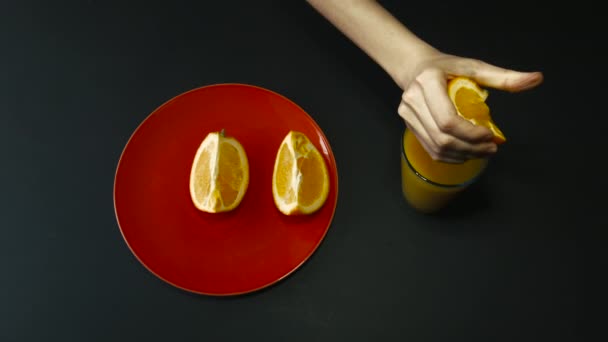 Exprimir a mano el jugo de naranja en un vaso — Vídeos de Stock