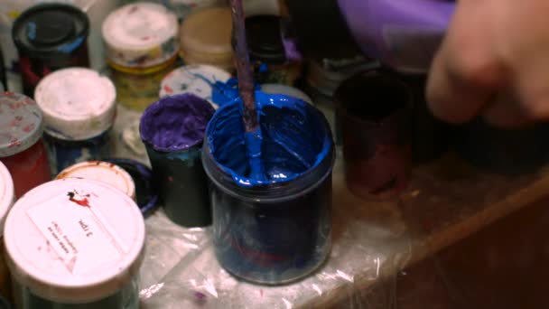 Glas mit blauer Farbe neben anderen Farben — Stockvideo