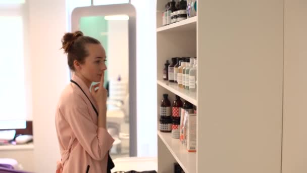 Vrouw kiest cosmetica in de winkel — Stockvideo