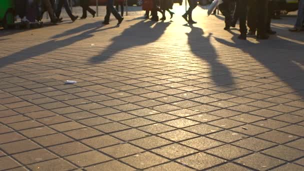 Mensen gaan op de weg in de stralen van het zonlicht — Stockvideo