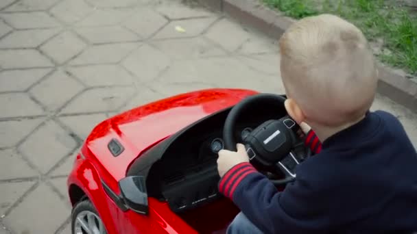 Criança dirigindo um carro de brinquedo — Vídeo de Stock