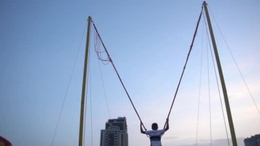 bir çocuk gökyüzüne karşı bir salıncak üzerinde